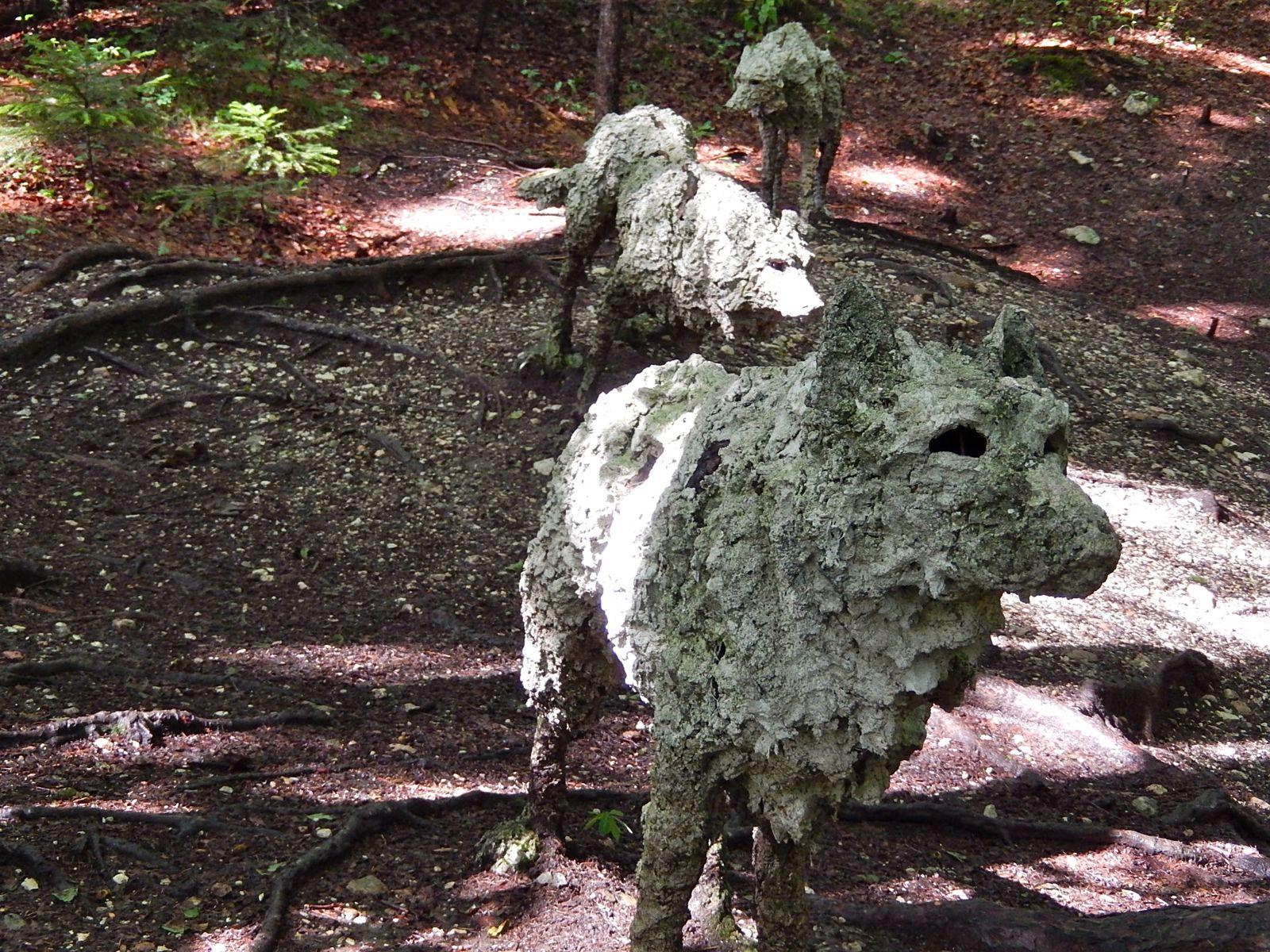 Ein Bild von 3 Wölfen im Wald, die sich auf den zweiten Blick aber als Landart-Kunstwerk in Pappmache herausstellt - als Metapher für schwierige Kategorisierung